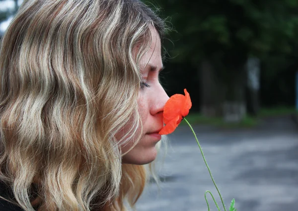 Kvinna med röd vallmo blomma — Stockfoto