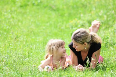 Young mother and her little daughter on the nature clipart