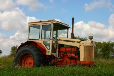 Broken Down tractor in a field. clipart