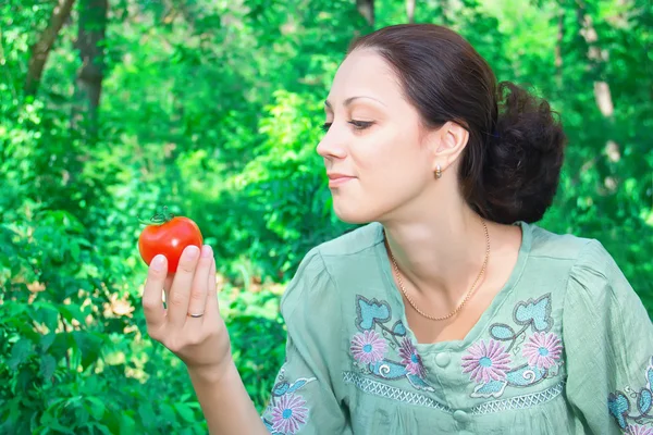 Une femme avec une tomate — Photo