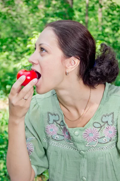 Uma mulher com um tomate — Fotografia de Stock