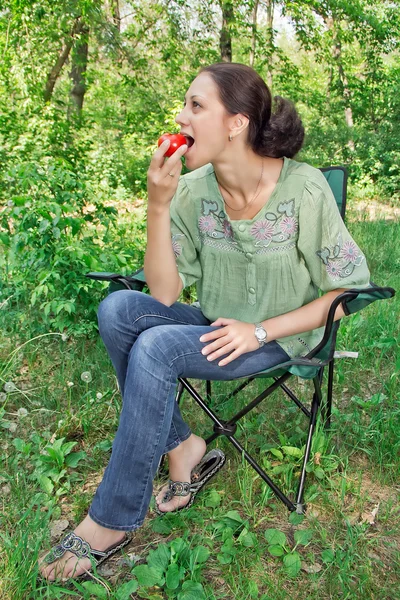Una mujer con un tomate — Foto de Stock