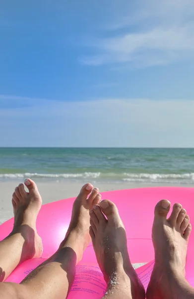 Пляжные ноги на розовом кольце — стоковое фото