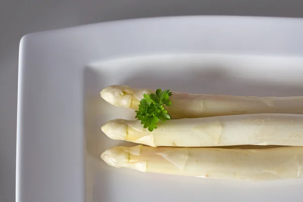 Asparagi bianchi con prezzemolo su un piatto — Foto Stock