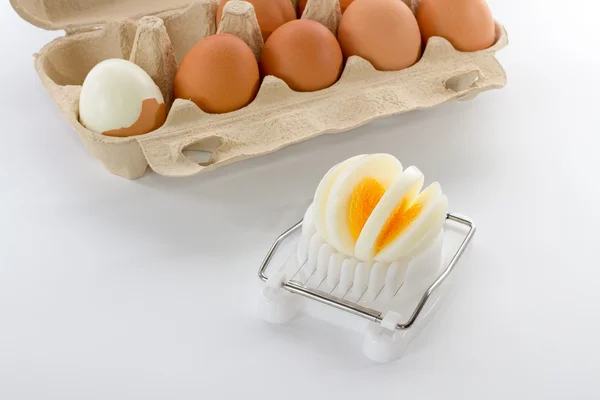 Egg slicer with a box of eggs — Stock Photo, Image