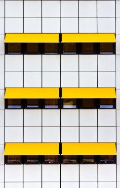 Facade with white tiles and yellow awnings clipart