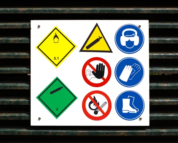 Hazard and safety symbols on door — Stock Photo, Image