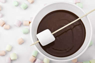 Closed up marshmallow in a stick and melted chocolate clipart