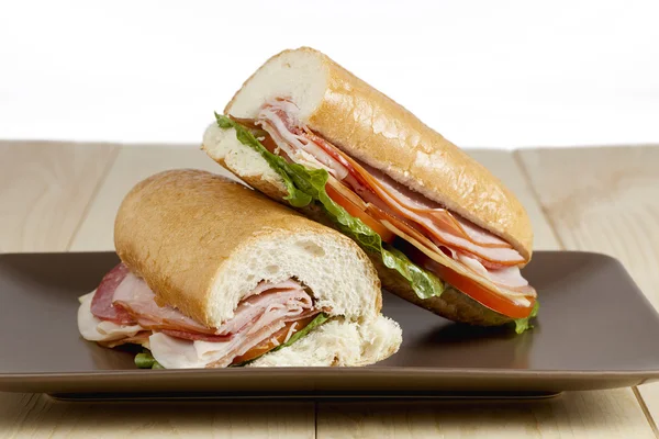 Jambonlu sandviç kahverengi plaka üzerinde dilim — Stok fotoğraf