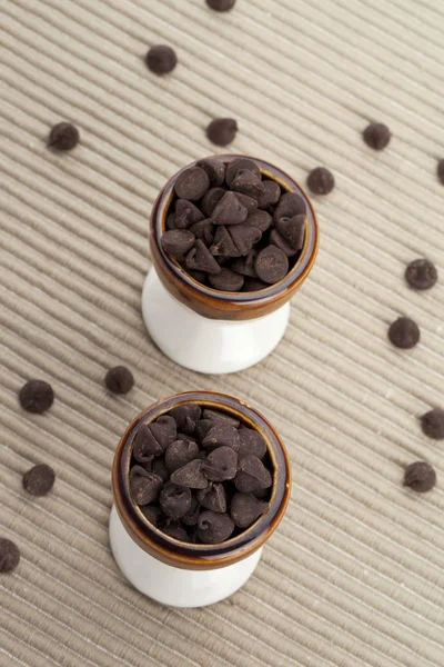 Zwei Tassen Schokoladenchips mit verirrten Chips auf der Seite — Stockfoto