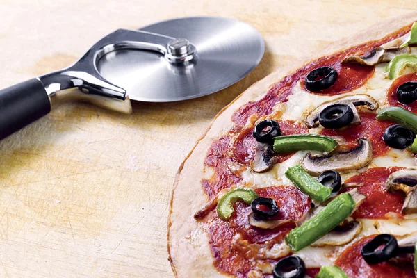 Pizza con rebanadora de pizza — Foto de Stock