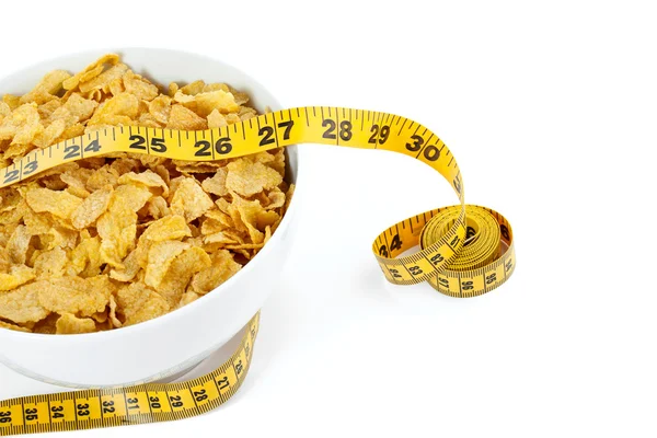 Corn flakes with yellow measuring tape — Stock Photo, Image