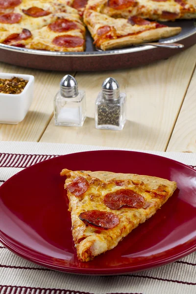 Pepperoni pizza with salt and pepper shaker — Stock Photo, Image