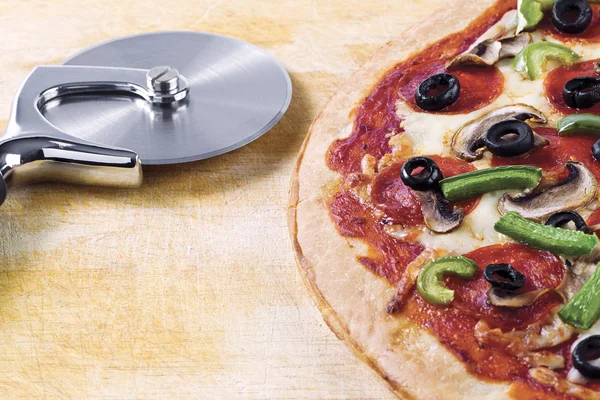 Cortador de pizza y pizza — Foto de Stock