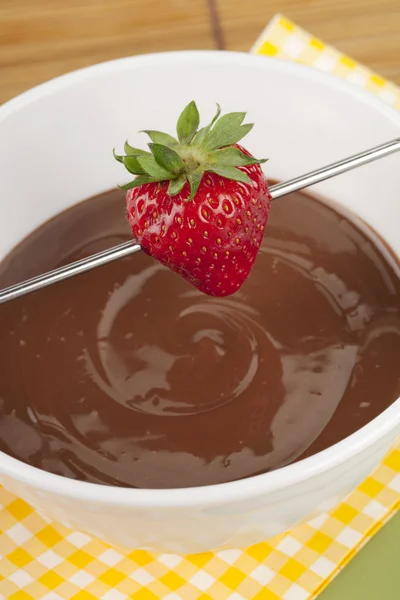 Erdbeere am Stiel über geschmolzener Schokolade — Stockfoto