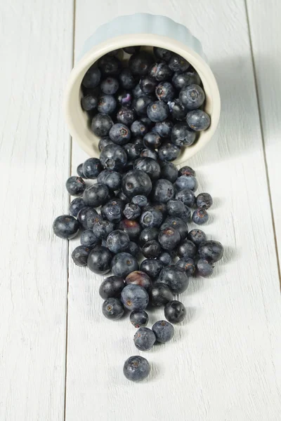 A bowl with spilled blueberries — Stock Photo, Image