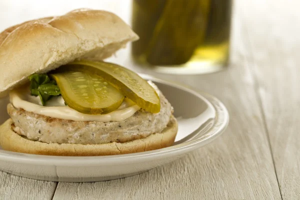 Chicken hamburger with slices of pickle — Stock Photo, Image