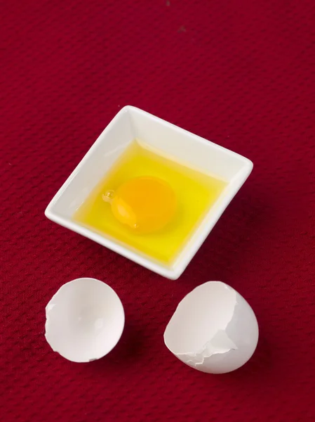 Brutna vita ägg skal med äggula i skål — Stockfoto