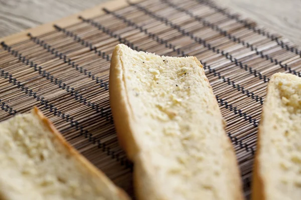 広がるニンニクとコショウで焼かれたバゲットのパンにバター — ストック写真