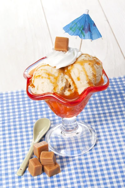 Karamell-Eis auf der Tasse mit Sonnenschirmdekoration — Stockfoto