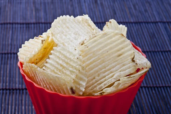 Fried potato chips in red plastic bowl — Stock Photo, Image