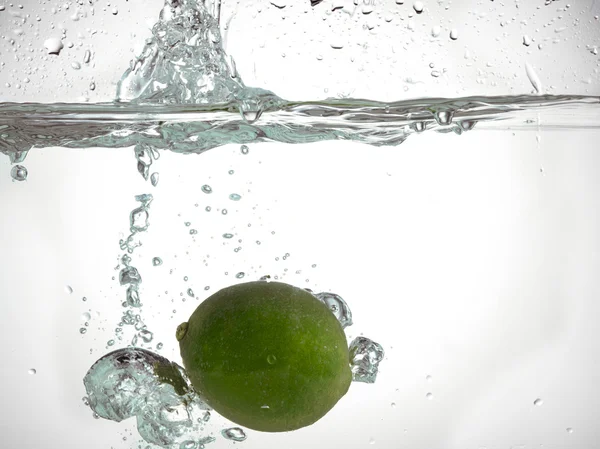 Limão caindo em água limpa — Fotografia de Stock