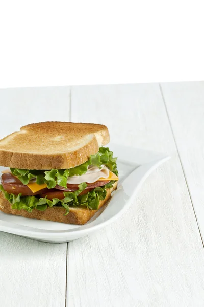 Сэндвич с ветчиной и жареным хлебом на белой тарелке — стоковое фото