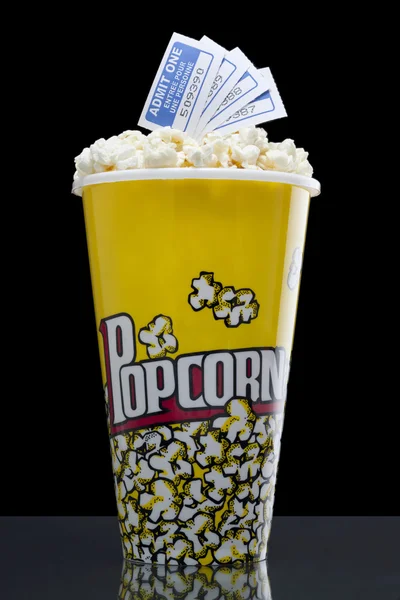 Popcorn und Tickets isoliert auf dem dunklen Hintergrund — Stockfoto
