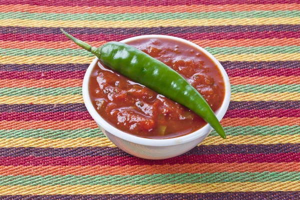 Trempette salsa épicée dans un bol avec du piment vert — Photo