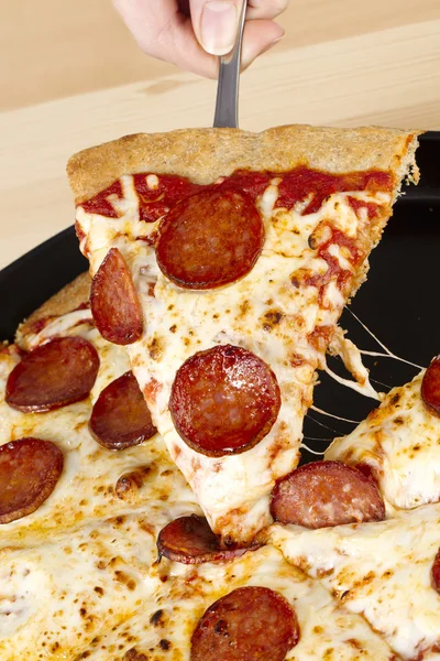 Retrato de una pizza que recoge a mano —  Fotos de Stock