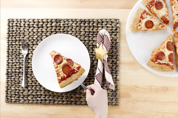 Poner pizza de pepperoni en un plato blanco —  Fotos de Stock