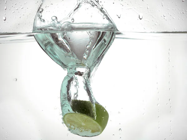 Plasterek limonki, zanurzone w wodzie — Zdjęcie stockowe