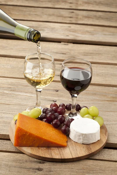 Вид на сыр с виноградом и вином — стоковое фото