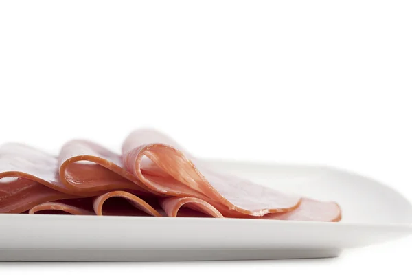 Slices ham on a white plate — Stock Photo, Image