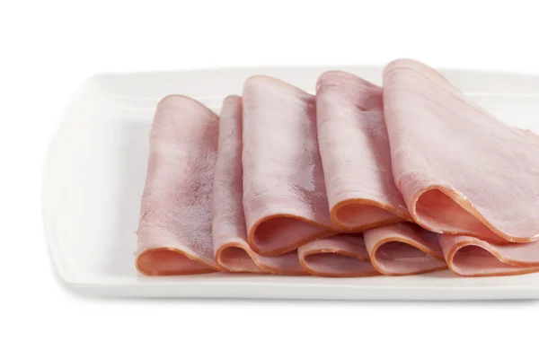 Slices of ham on white plate — Stock Photo, Image