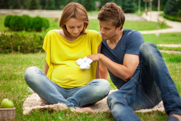 Unga gravid kvinna med ung man på picknick Stockfoto