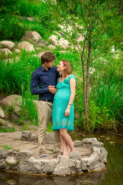Young pregnant woman with young man outdoor — Stock Photo, Image