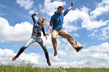 Young enthousiastic couple jumping up in the air clipart