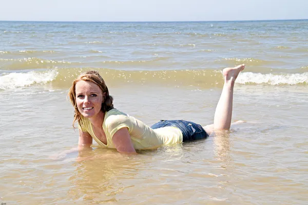 Szczęśliwa kobieta leżąc w wodzie z Morza Północnego — Zdjęcie stockowe