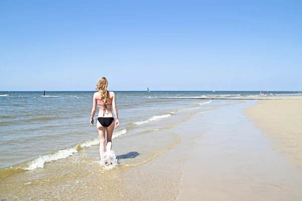 Hermosa joven mujer caminando en el paseo marítimo del océano — Foto de Stock