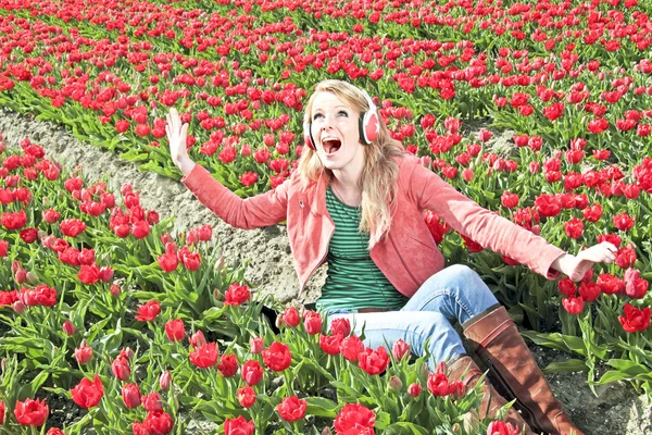 Menina feliz apreciando a música nos campos de tulipas do Nethe — Fotografia de Stock