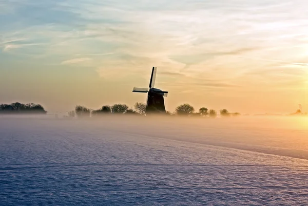 Traditionelle Windmühle in der Dämmerung mit Nebel und Schnee im Winter in — Stockfoto