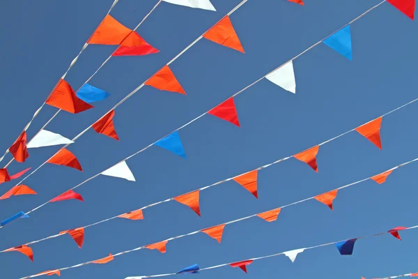 Red, white and blue colored flags against a blue sky — Stock Photo, Image