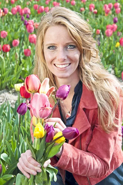 Beautiful woman with tulips in the fields — Stock Photo, Image