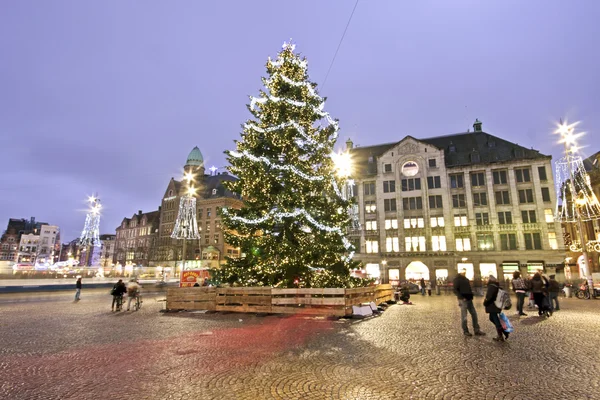 Vánoční strom na přehradě palác v Amsterdamu v Nizozemsku za soumraku — Stock fotografie