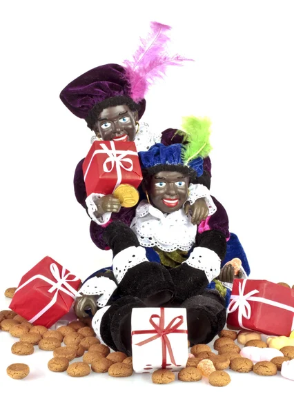 Zwei schwarze Piet mit einer Tüte voller Ingwernüsse und Bonbons — Stockfoto