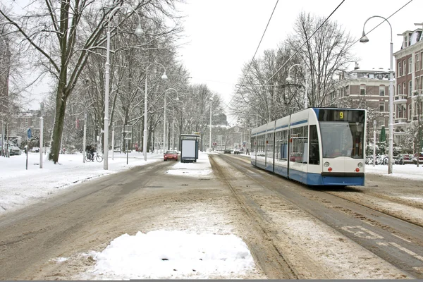 Tramvajové jízdy v zasněžené amsterdam, Nizozemsko — Stock fotografie