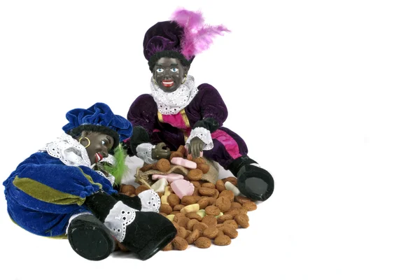 Traditional dutch culture: Two black Piet with a bag full of gingernuts and candies at 5th december — Stock Photo, Image