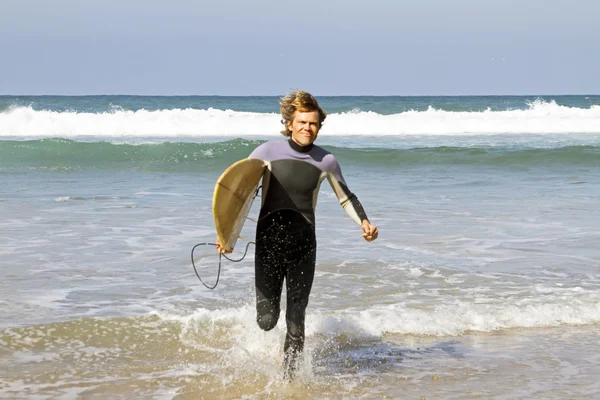 Surfer met zijn surfplank aan de Atlantische Oceaan — Stockfoto