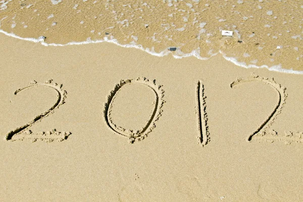 Powitanie nowego roku 2012, wiadomości w piasku na plaży, w pobliżu oceanu — Zdjęcie stockowe